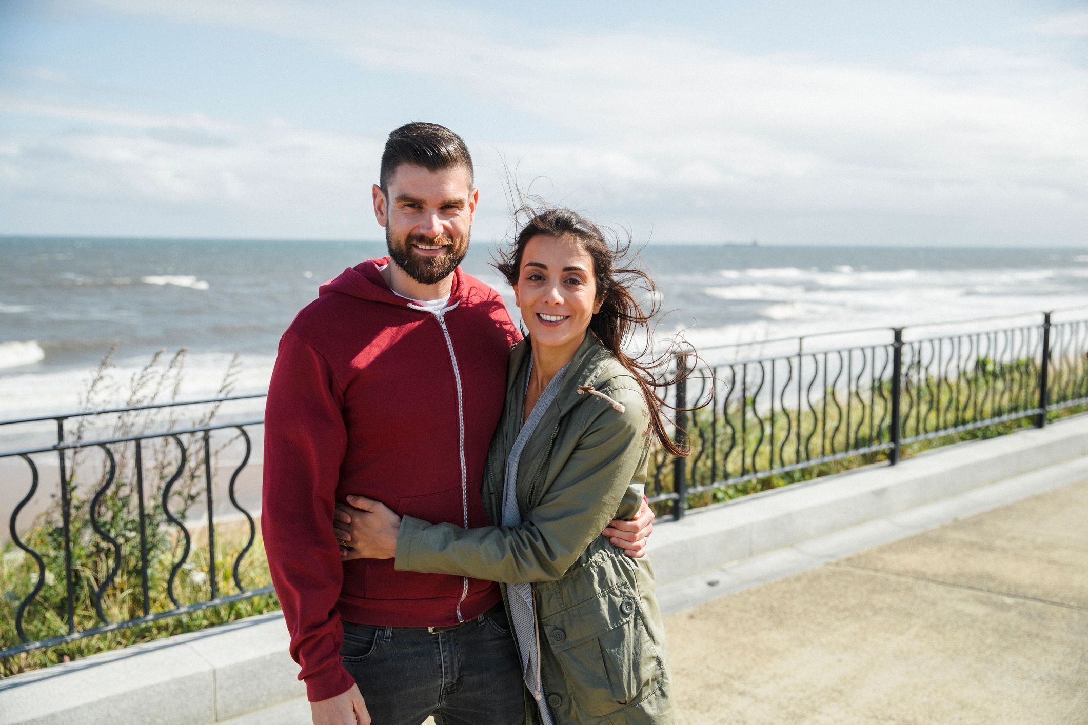 Romantic couple portrait on a beach promenade