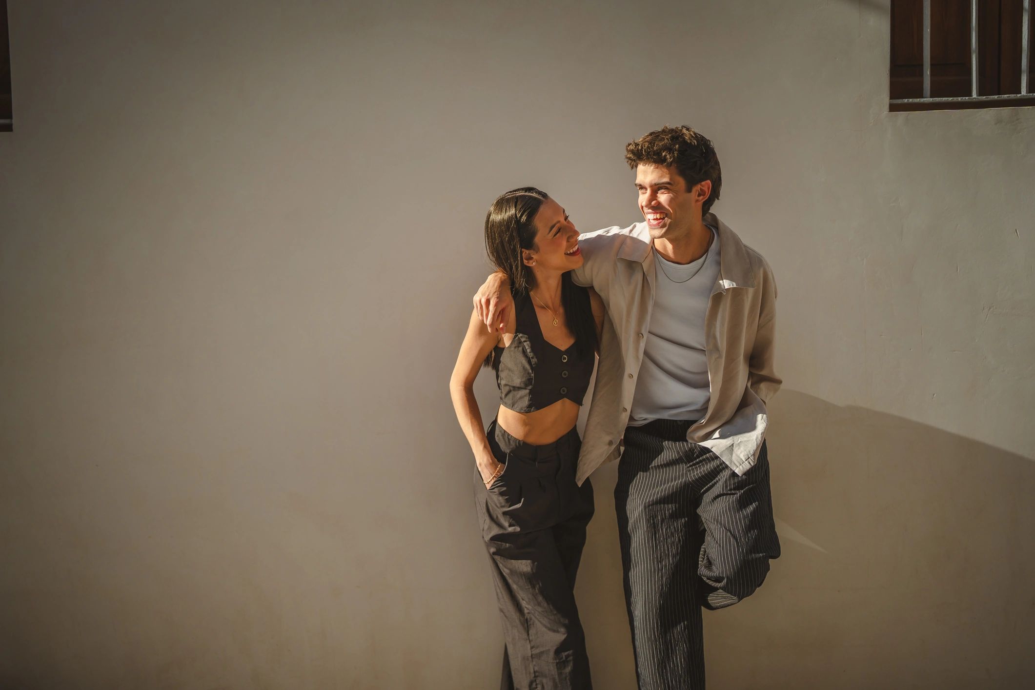 Young couple smiling outdoors in warm light